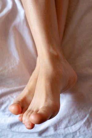 young girls toes are healthy and beautiful. Well-groomed toes. Concept for medical articles and ointments - the image of the toes and feet. Image of legs with space for inscriptions and advertising.の写真素材