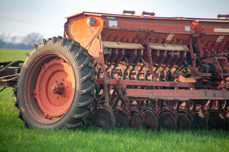 seeders work in the field on the ground in the spring. The mechanization of modern agriculture agricultural machines. Spring field work on farmlands.の写真素材