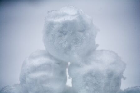 real snowballs with their hands clasped from the fresh snow in winter on the streetの写真素材