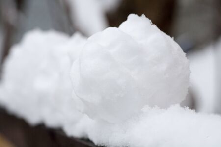 real snowballs with their hands clasped from the fresh snow in winter on the streetの写真素材