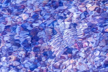 sea pebbles colored granite on the beach background stones. The shore of the beach with sand and...