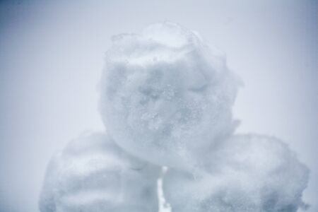real snowballs with their hands clasped from the fresh snow in winter on the street