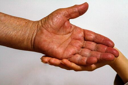 An elderly woman grandmother and a young girl hold hands. Support for the elderly from young people...