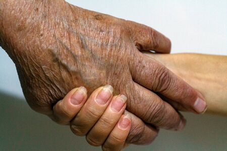 The process of aging of human skin - wrinkled hands of a very old man who lived 90-100 years with...