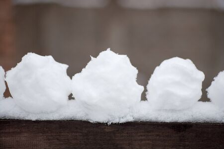 real snowballs with their hands clasped from the fresh snow in winter on the streetの写真素材