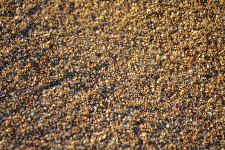 golden sand on the beach closeup glitters with grains poured under the rays of the setting sunの写真素材