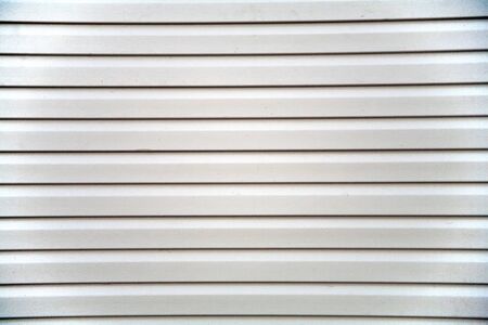 Wall covering of the frame house with panels of vinyl siding of gray color. Decorating the house with siding. The master updates the look of the old house with siding.の写真素材