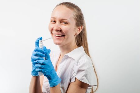 Young doctor uses healing spray to relieve sore throat with sore throat and flu. COVID-19の写真素材