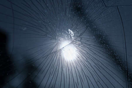 broken glass. Car glass cracked from an accident. Armored glass after impact. glass reinforced with a film after being hit by a bullet.の写真素材