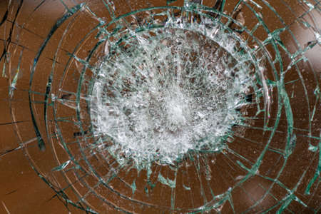 broken glass. Car glass cracked from an accident. Armored glass after impact. glass reinforced with a film after being hit by a bullet.の写真素材