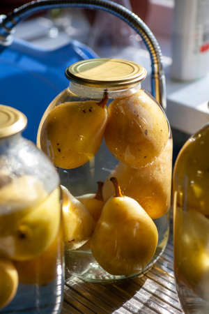 pear compote. Canned pears in a glass jar. Homemade fruit supplies for snake.の写真素材