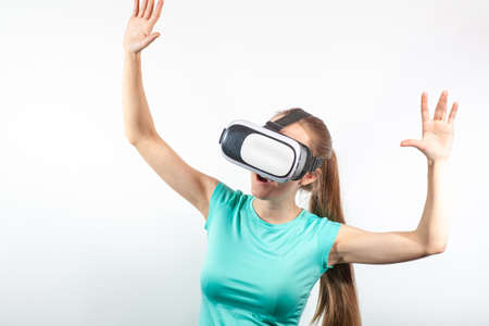Girl in virtual reality glasses watching surprised shocking video. Young woman looking at futuristic...