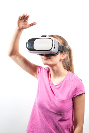 Girl in virtual reality glasses watching surprised shocking video. Young woman looking at futuristic social network map conceptの写真素材