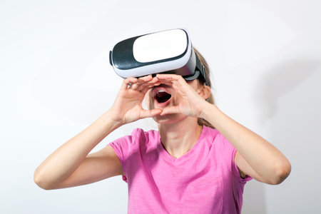 Girl in virtual reality glasses watching surprised shocking video. Young woman looking at futuristic social network map conceptの写真素材