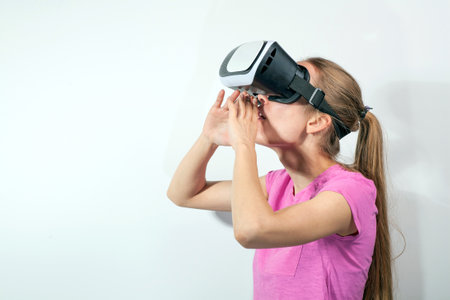Girl in virtual reality glasses watching surprised shocking video. Young woman looking at futuristic social network map conceptの写真素材