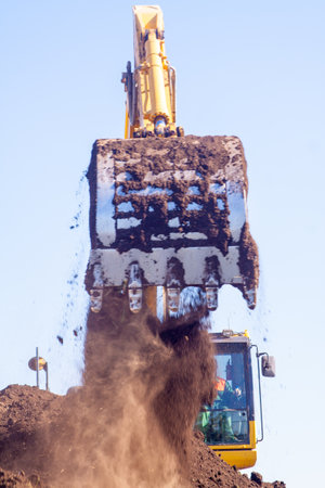 A large construction excavator of yellow color on the construction site in a quarry for quarryingの写真素材