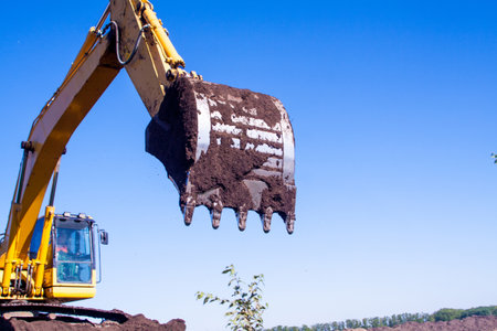 A large construction excavator of yellow color on the construction site in a quarry for quarryingの写真素材