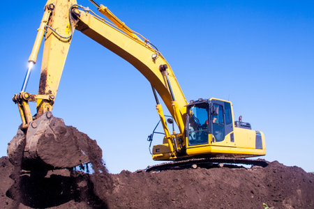 A large construction excavator of yellow color on the construction site in a quarry for quarryingの写真素材