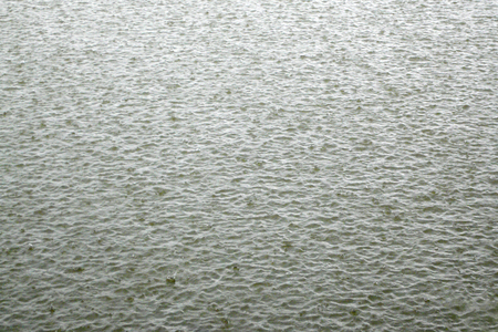 Damaged pond surface during heavy rainfall, backgroundの写真素材