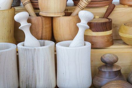 Collection of handmade wooden mortars and pestles arranged on display, highlighting natural wood tones, artisanal craftsmanship, and the rustic charm of traditional kitchen accessories.の写真素材