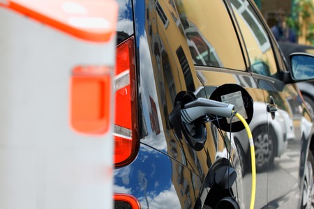 Close up of the power supply plugged into an electric car being charged.