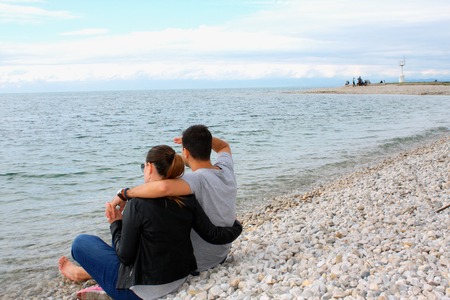 Back view of a romantic couple at beach during summer vacationの写真素材