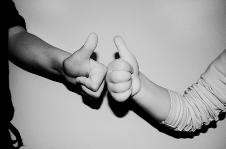 kids showing two thumbs up on b/w backgroundの写真素材