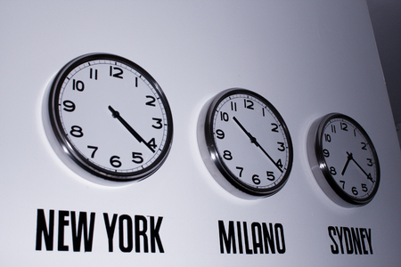 Clock on the wall showing time in the worldの写真素材