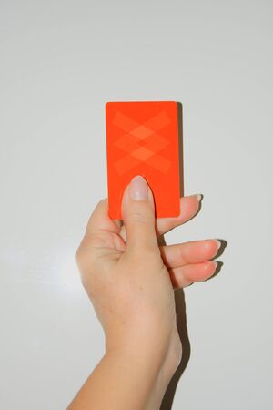 sport, caution, game and people - close up of referee hands with whistle showing red cardの写真素材