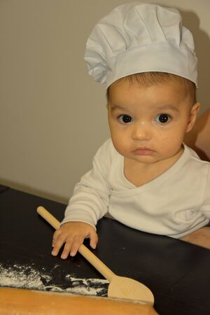 Cute baker in kitchen at homeの写真素材