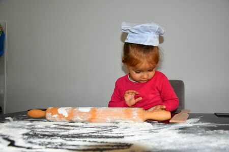 girl decorating Christmas cookies in the kitchenの写真素材