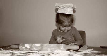 girl decorating Christmas cookies in the kitchenの写真素材