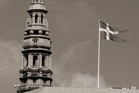 Danish Flag In The Wind next to the church tower in Copenhagenの写真素材