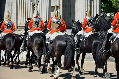 Royal guards on horseback dressed in ceremonial red coats pass in a parade in London, England, UKのeditorial素材