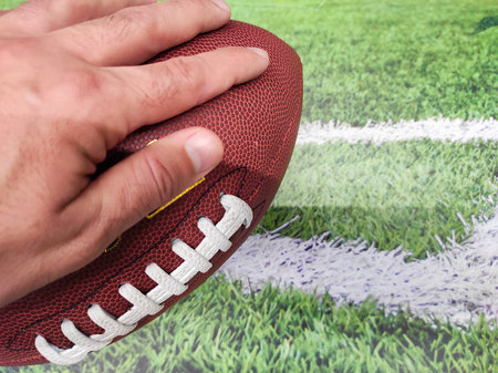 American football ball on the field with white line on the background.の写真素材