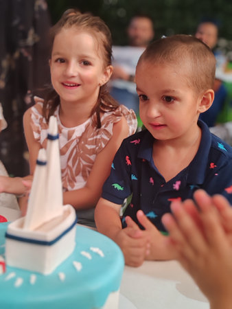Children play with cake at birthday party. Little boy and girl having funの写真素材