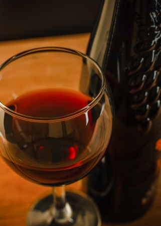 Red wine in a clear glass near the bottleの写真素材