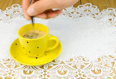 human hand  and  silver spoon stirs coffeeの写真素材