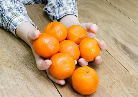 wooden texture on human hands and orangesの写真素材