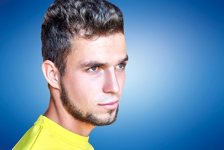 handsome man looking in one direction on a gray wooden backgroundの写真素材