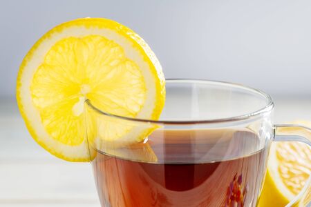 Tea in a cup with lemon on a wooden background.の写真素材