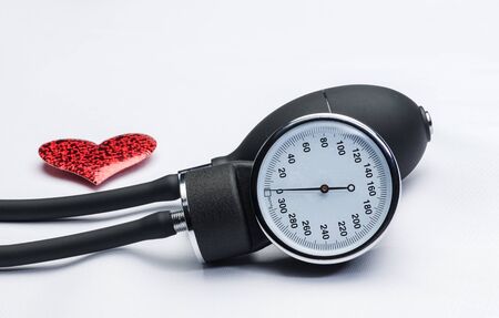 Black tonometer and heart isolated on whiteの写真素材