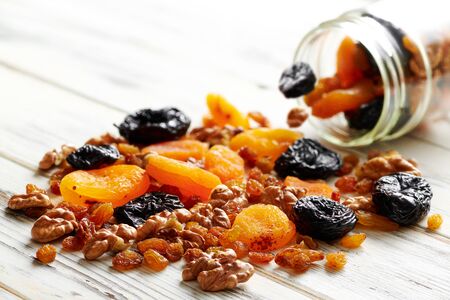 Nuts and dried fruits on a pile on a wooden white backgroundの写真素材