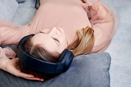 girl relaxed on the couch listening to music on headphones