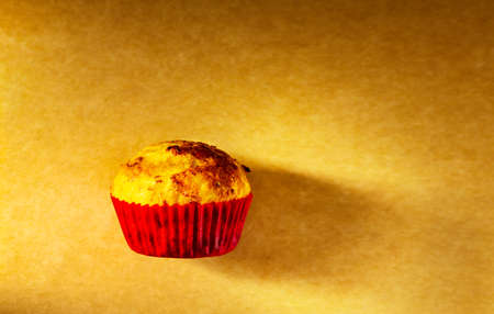 one cupcake is shot with side light in the studio on an old paper background. Home kitchenの写真素材