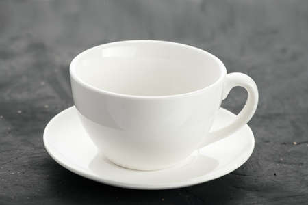 close-up shot of a white porcelain mug on a black background