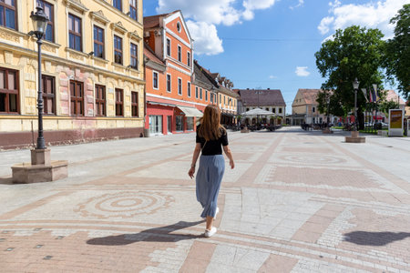 Vinkovci, Croatia-July 14th, 2020: Beautiful girl with long brown hair walking through the town of...