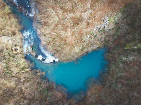 Aerial shot of beautiful Sluncica river wll, hidden deep in the  mountain forest with stone cascades in the river streamの写真素材