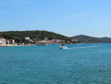 Tisno, Croatia-June 3rd, 2021: Boats approaching small town of Tisno on the Murter island, Croatia, famous for summer music festivals and wonderful turquoise sea on the Adriatic coastのeditorial素材