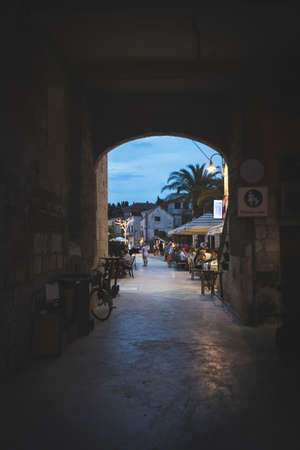 Rogoznica, Croatia-July 05th, 2021: Stone passage leading to the beautiful, open square with restaurants in the small fishing town of Rogoznicaのeditorial素材